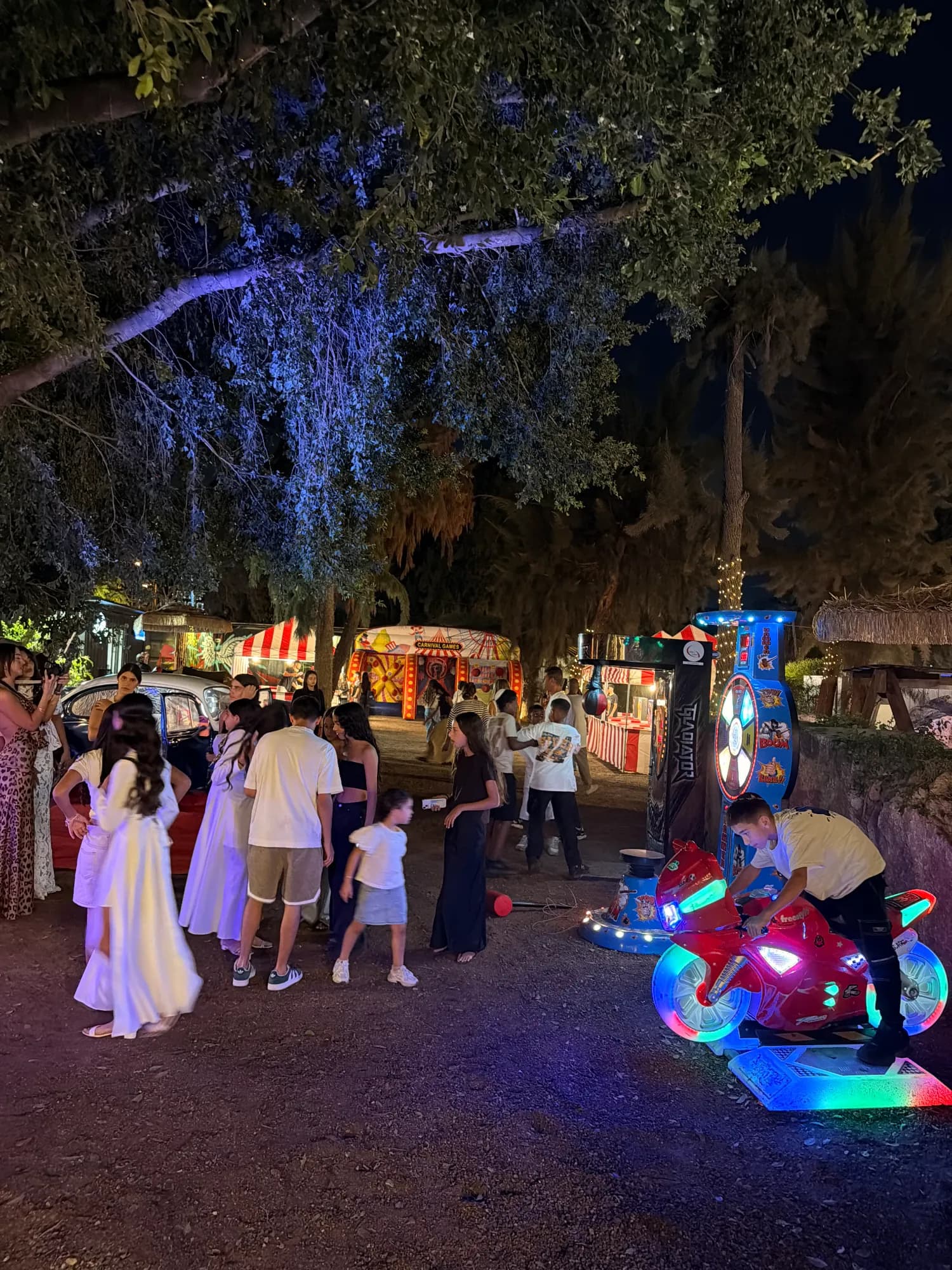 משתתפים ליד מתקני משחק מוארים בחצר בלילה